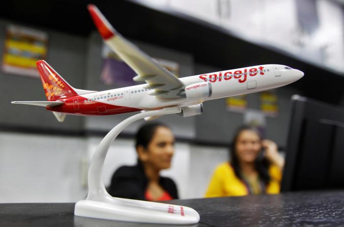 Employees work inside a travel agency office beside a model of a SpiceJet aircraft in the western Indian city of Ahmedabad February 14, 2014. REUTERS/Amit Dave/File Photo