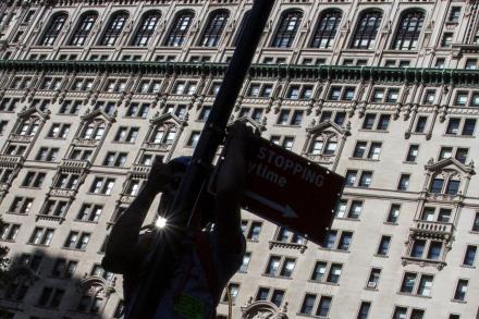 A man is silhouetted as he climbs a poll to signal to comrades during the 'Flood Wall Street' demo<em></em>nstration in Lower Manhattan, New York September 22, 2014.   REUTERS/Adrees Latif/File Photo