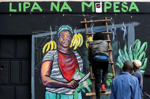 An artist works on a mural advocating for retail M-Pesa mobile phone cashless payments in Nairobi