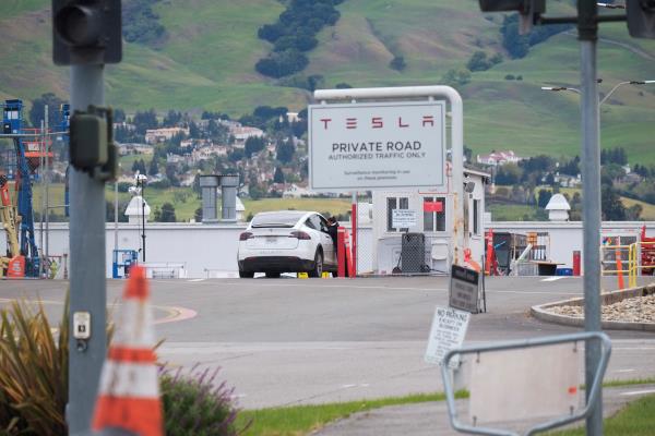 An employee of a Tesla Inc's U.S. vehicle factory is seen at a security gate in Fremont, California