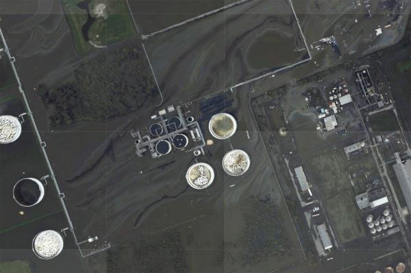 A sheen appears on the flooded property of the Phillips 66 Alliance Refinery