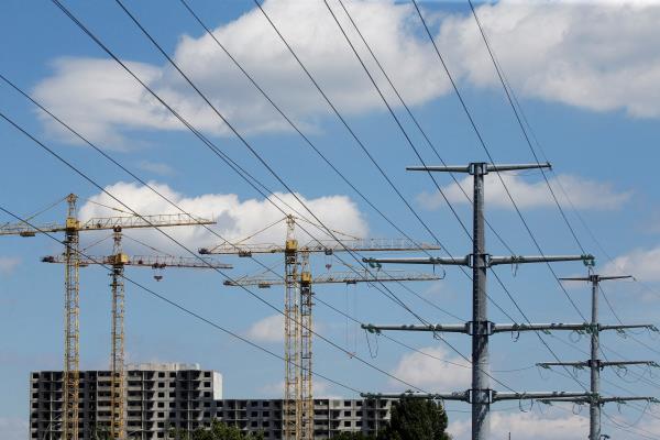 Building cranes and power lines co<em></em>nnecting pylons of high-tension electricity are seen in Kyiv
