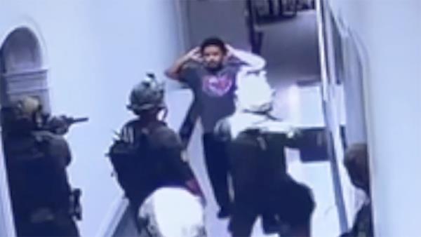 Justin Combs, in a purple shirt, being apprehended by Homeland Security agents during a raid at Diddy's house in Holmby Hills, California