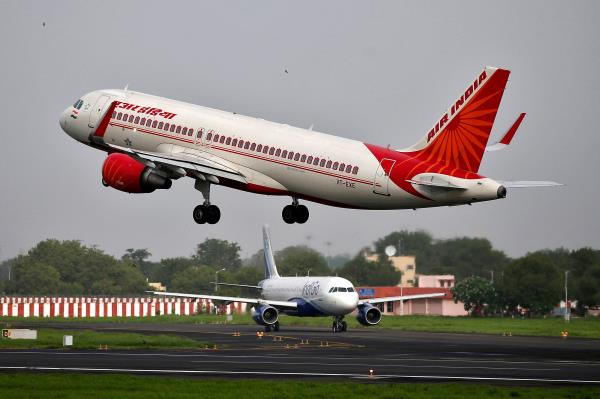 An Air India Airbus A320 aircraft takes off as an IndiGo Airlines aircraft waits for clearance at the Sardar Vallabhbhai Patel Internatio<em></em>nal Airport in Ahmedabad