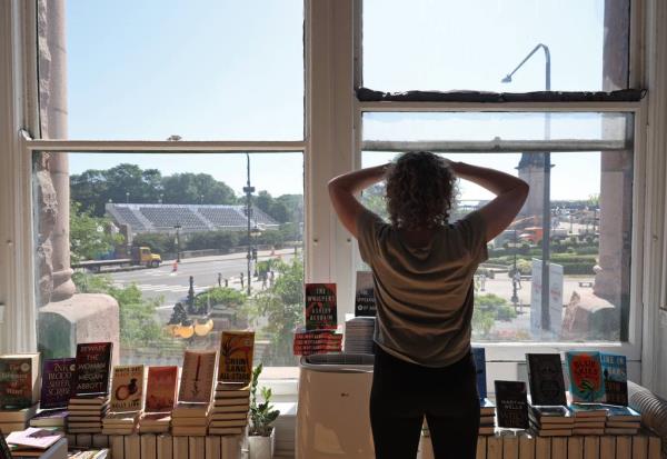 Kristin Enola Gilbert, co-owner of Exile in Bookville bookstore, looks from the store's windows at NASCAR Chicago Street Race co<em></em>nstruction in the 400 block of South Michigan Avenue, June 24, 2023.