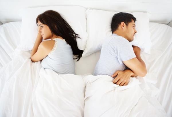 Couple facing away from each other in bed