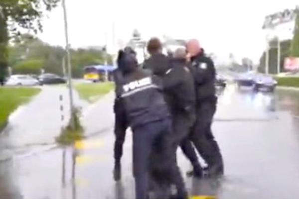 The 'priest' was detained and dragged away from the road by police officers
