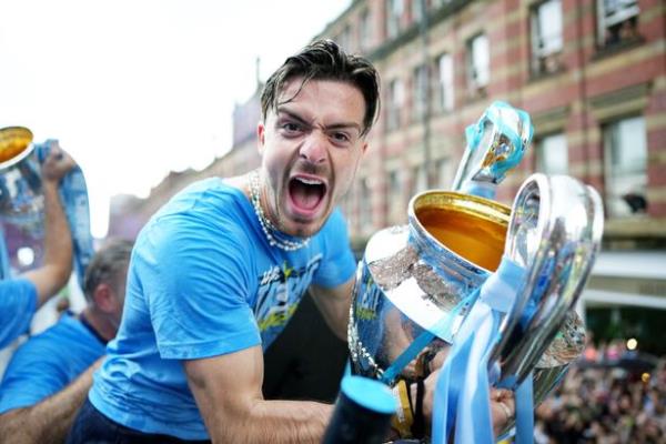 MANCHESTER, ENGLAND - JUNE 12: Jack Grealish of Manchester City celebrates with the UEFA Champions League Trophy on the Open-Top Bus during the Manchester City trophy parade on June 12, 2023 in Manchester, England.