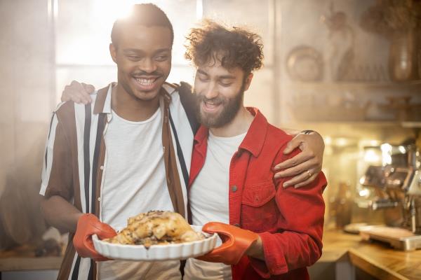 couple talking in the kitchen. you see the back of a female and a male holding a coffee mug smiling