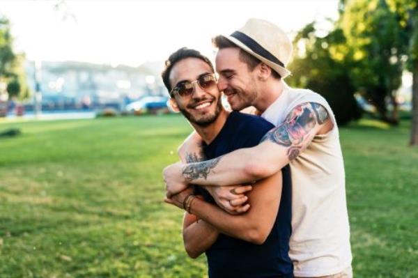 Happy Middle Aged Couple hugging outdoors with trees in the background