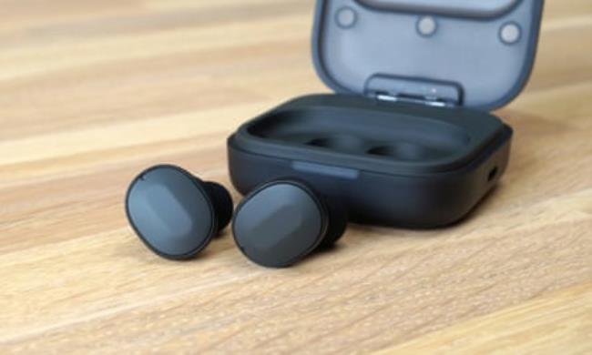 The Fairphone Fairbuds earbuds and case on a table.