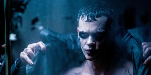 Bill Skarsgård as The Crow puts on a leather jacket in The Crow.