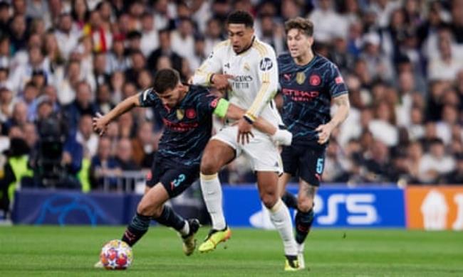 Jude Bellingham is held off by Rúben Dias as John Sto<em></em>nes watches on during Real Madrid’s draw with Manchester City
