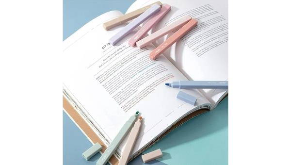 Eight Mr. Pen Aesthetic Pastel Highlighters of different colors placed on an open book.