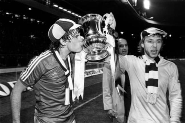 Tottenham’s Glenn Hoddle kisses the FA Cup as he and Steve Archibald take it on a lap of Wembley after the 1-0 defeat of QPR after the replay of the final in 1982.