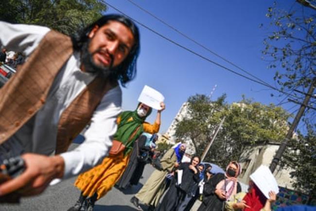 A Taliban member attacks a foreign photographer covering a women’s rights protest in Kabul in October 2021.