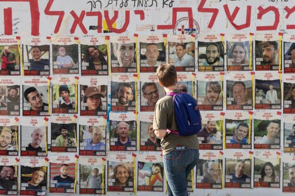 A women looks at photos of hostages held by Hamas in the Gaza Strip covering a wall on May 01, 2024 in Tel Aviv, Israel.