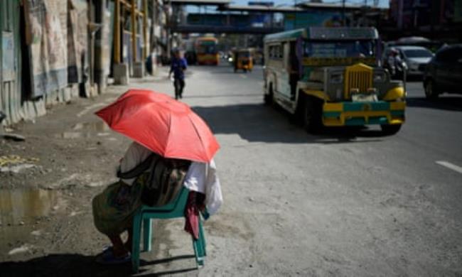 A street vendor uses an umbrella for protection against the sun in the Philippines capital of Manila last week.