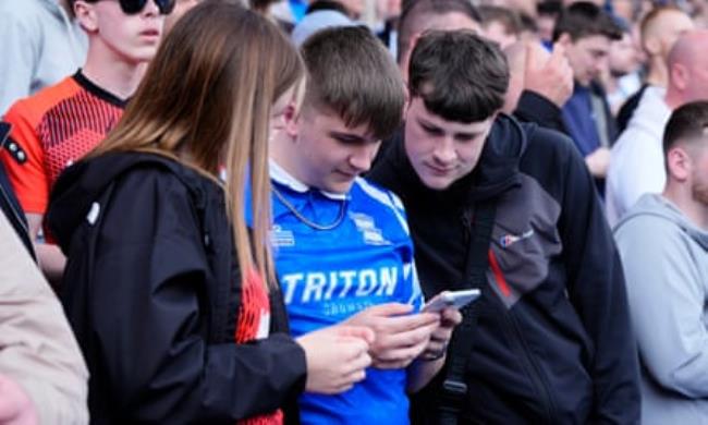 Birmingham fans check the scores from elsewher<em></em>e on their phones