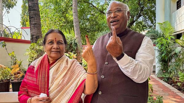 Co<em></em>ngress President Mallikarjun Kharge with his wife Radhabai Kharge shows his ink-marked finger after voting during the third phase of Lok Sabha elections, in Kalaburagi.