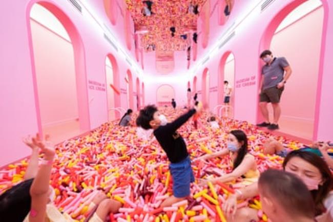 kids play in a pink room full of giant ice cream sprinkles