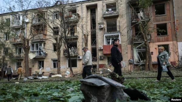 Local residents walk near an apartment building damaged by a Russian air strike, amid Russia's attack on Ukraine, in Kharkiv, Ukraine, May 5, 2024.