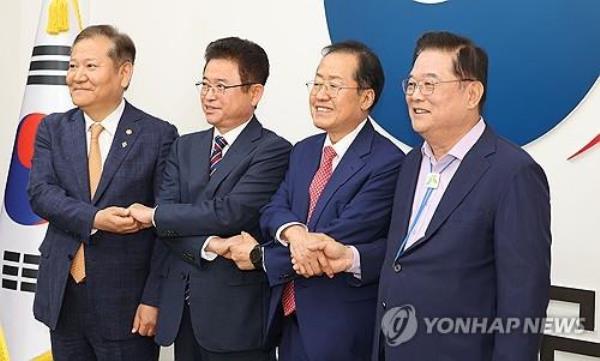 Daegu Mayor Hong Joon-pyo (2nd from R), North Gyeo<em></em>ngsang Gov. Lee Cheol-woo (2nd from L), Minister of the Interior and Safety Lee Sang-min (L) and Woo Dong-gi, chairman of the Presidential Committee for Decentralization and Balanced Development, pose at the Seoul Government Complex on Oct. 21, 2024, after agreeing to merge Daegu and North Gyeo<em></em>ngsang by July 2026. (Pool photo) (Yonhap)