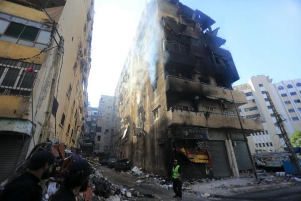 A municipal worker stands next to a damaged building in the aftermath of an overnight Israeli strike in Beirut's southern suburbs on September 29, 2024. Israel said on September 29 that it was carrying out new air raids against 