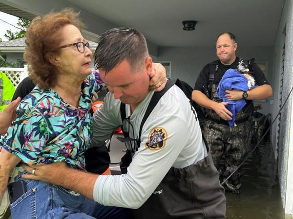This photo provided by Venice Police Department rescue crews assist residents after co<em></em>nducting door-to-door wellness checks, in coastal areas that were flooded by Hurricane Helene on Friday, Sept. 27, 2024 in Venice, Fla . (Venice Police Department via AP)