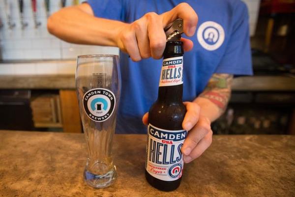 An image of a person opening a bottle of beer