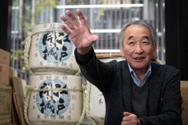 President Shunichi Saito, with barrels of Edo Kaijo sake behind him, explains his company's brewing history.