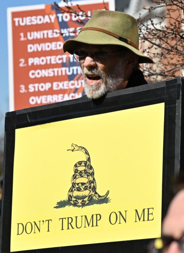 Protesters carry signs. Protesters rally on President's Day at Lawyers Mall in Annapolis against the policies of President Do<em></em>nald Trump and Elon Musk as part of the natio<em></em>nwide "50501" Movement. (Paul W. Gillespie/Staff)